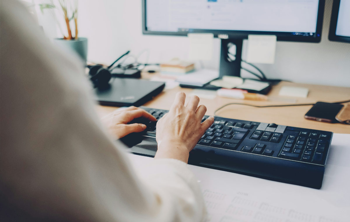 A businesswoman implementing DIY B2B marketing strategies sitting at a desktop computer